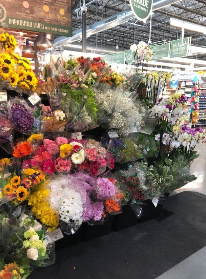 Best places to buy flowers showing a the display at Whole Foods. Gerber daisies, white daisies, babies breath, roses, sunflowers, and more.