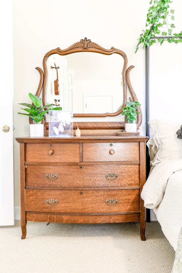 Antique bureau used as a nightstand in a Cottagecore bedroom