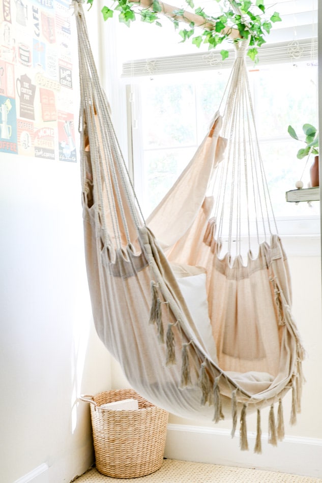 Hanging chair in a reading nook in a teenagers cottagecore bedroom