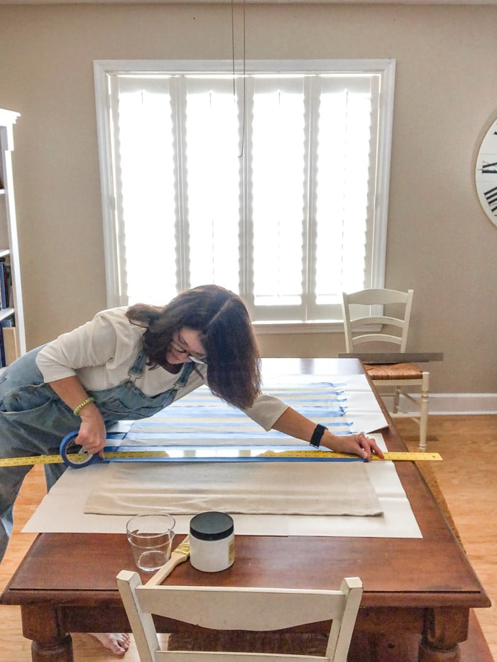 DIY rug using a drop cloth and chalk paint and painters tape to paint stripes