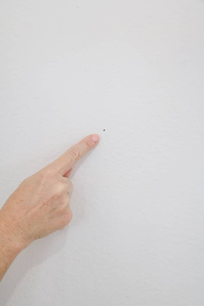 How to hang a gallery wall showing where your mark is for when you hammer the nail.  