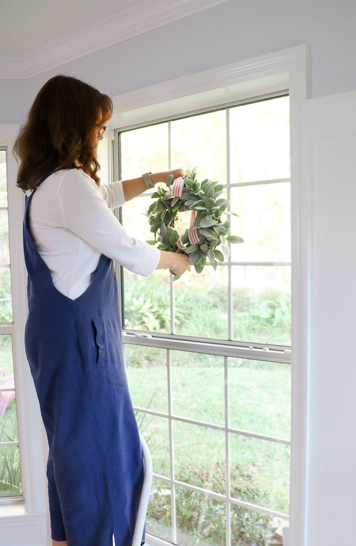 How to hang a wreath with ribbon on a window.  This simple DIY will show you two ways to hang wreaths on windows inside your home.  On this step hang the wreath on the hook.