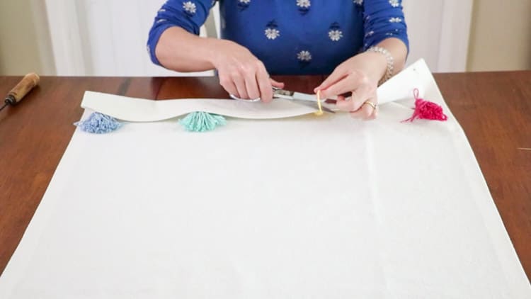 Attaching tassels to a dropcloth rug by tying them into place