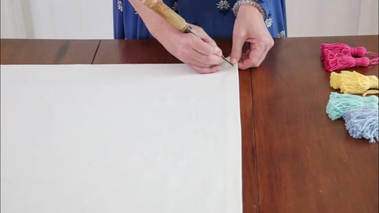 How to make a drop cloth rug by marking where you want your tassels to go and then making a hole with a sharp object like an ice pick.