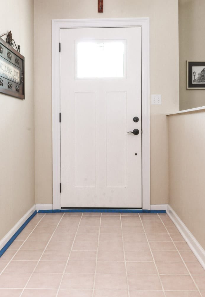 Paint over tile floors by taping the baseboard first