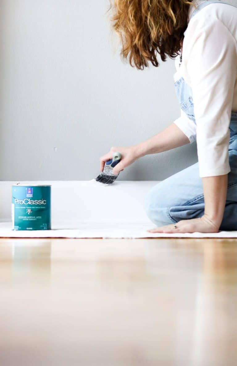 best diy painting tools showing me painting the floor boards on a dropcloth
