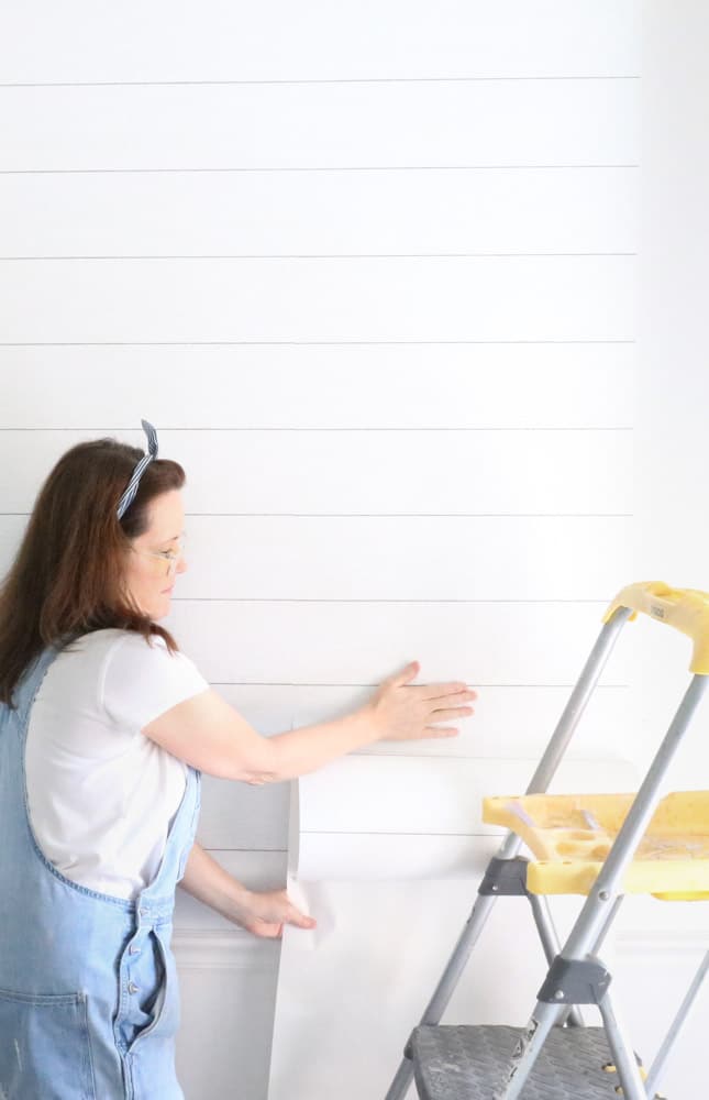 How to apply peel and stick wallpaper on an accent wall with a shiplap wall covering.
