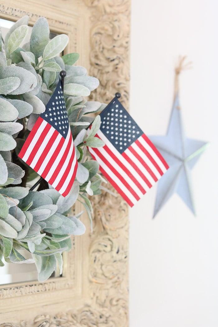 red, white and blue decorations stick flags in a lambs ear wreath